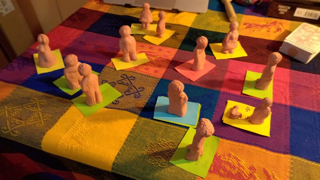foglietti di carta colorati e omini in terracotta su un tavolo: nelle costellazioni familiari individuali si utilizzano oggetti al posto dei rappresentanti umani