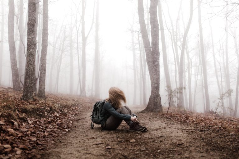 ragazza seduta in un bosco in autunno