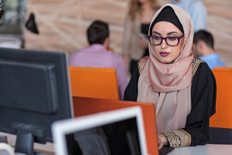 donna con velo islamico studia davanti a un computer