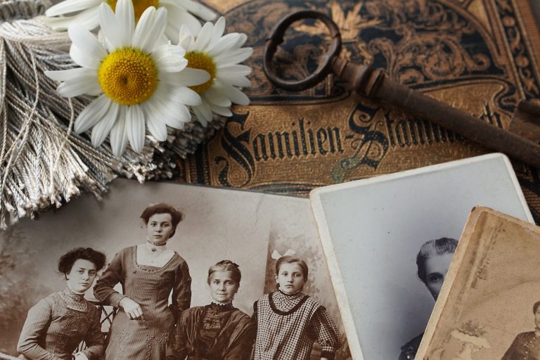 foto di famiglia in bianco e nero con fiori e un libro. Le costellazioni familiari mostrano i legami che abbiamo con i nostri antenati