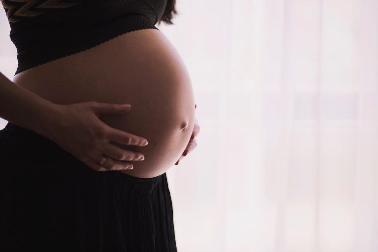 pancia di una donna in gravidanza: la prima ferita o ferita primordiale può svilupparsi già durante la gestazione