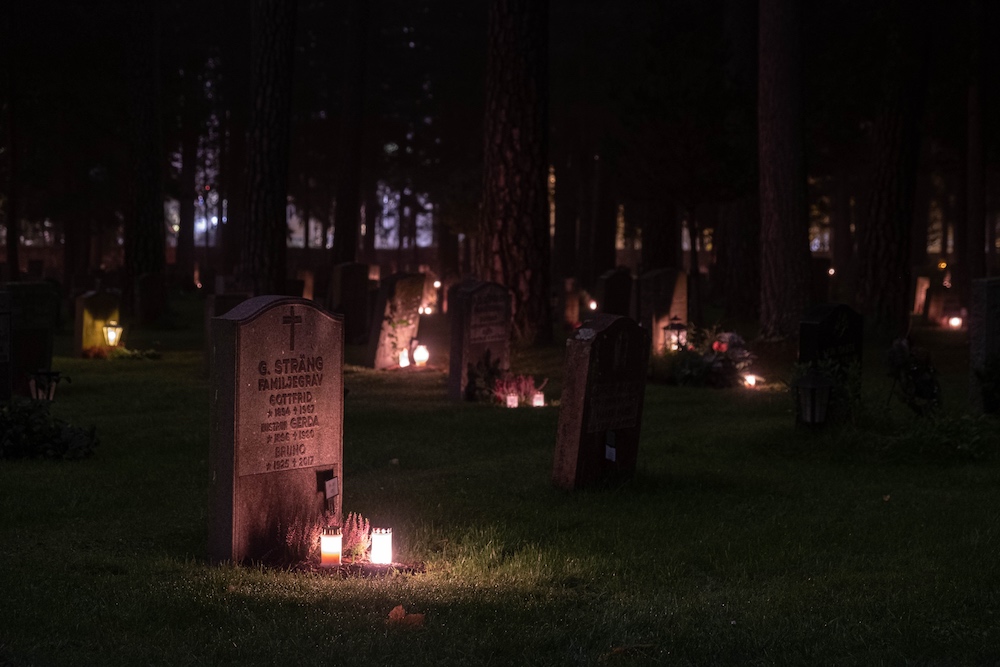 lapidi illuminate da candele di notte per la la festa dei morti
