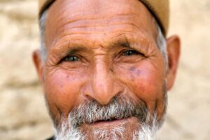 viso di uomo anziano che sorride: epigenetica e costellazioni familiari indicano la felicità come condizione necessaria alla vita