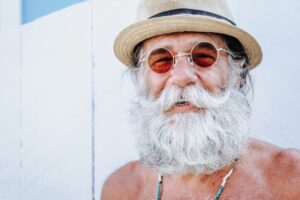 viso di uomo anziano che sorride: epigenetica e costellazioni familiari indicano la felicità come condizione necessaria alla vita