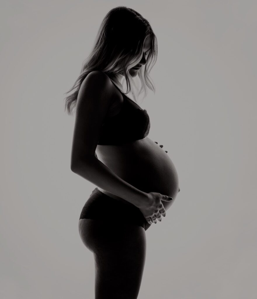 donna in gravidanza con pancia molto grande vista di lato. La difficoltà a rimanere incinta può essere superata lavorando spiritualmente