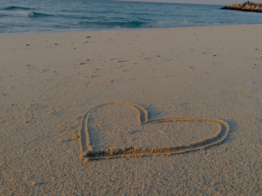 Un cuore disegnato sulla sabbia di una spiaggia: il simbolo dell'impermanenza