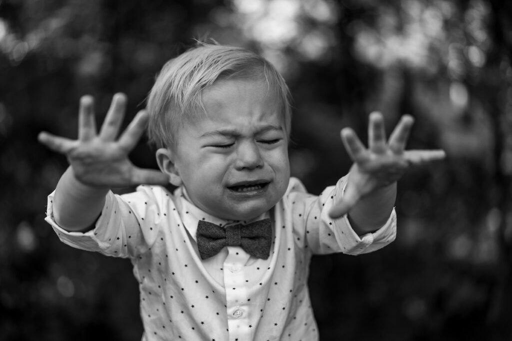 bambino piange con gli occhi chiusi: l'ego nasce e si sviluppa da bisogni infantili