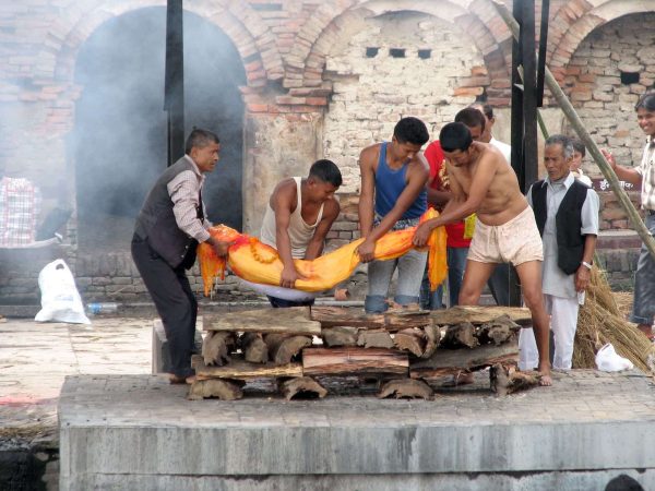 un cadavere viene adagiato sulla pira per la cremazione a Kathmandu in Nepal.