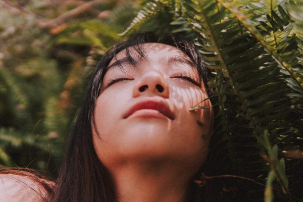 una donna a occhi chiusi percepisce il sole sul viso. La sensibilità è una qualità diversa dalla fragilità