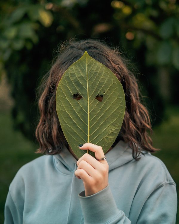 donna si copre il viso con una foglia: lo psicomago si disidentifica dal suo ego