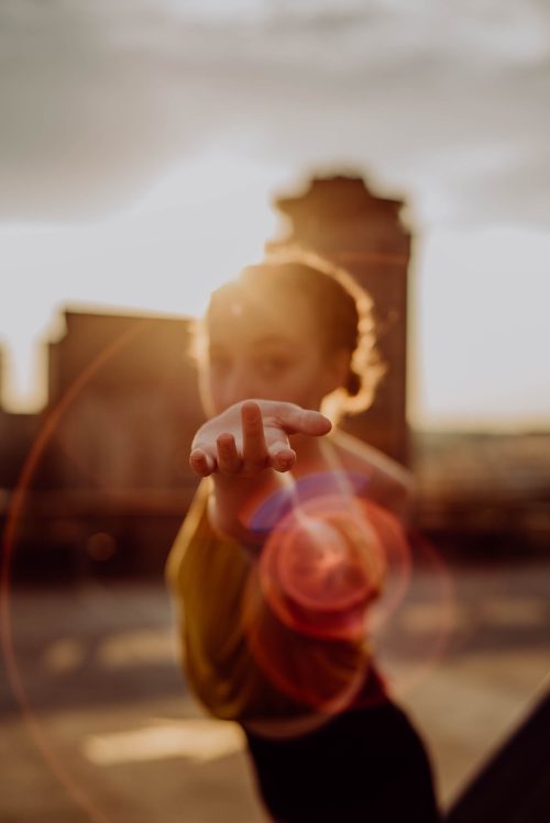 donna porge la mano con il sole alle spalle: i miracoli accadono ogni giorno nei piccoli gesti