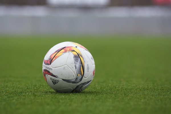 pallone da calcio in un prato: il calcio spesso è causa di infortuni alle ginocchia